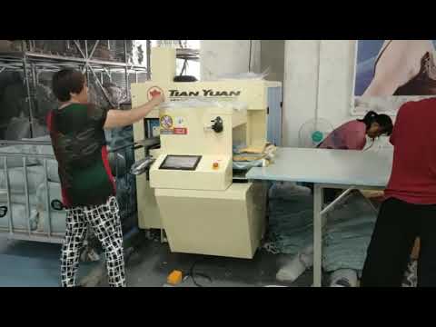 Compact coil packing machine for sheet and blanket rolls.