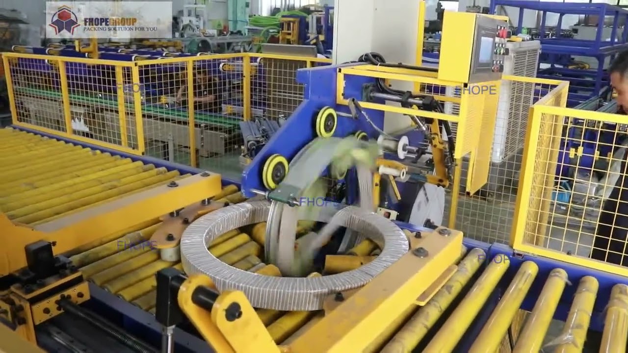 Improved horizontal coil packer with arm for secure packaging.