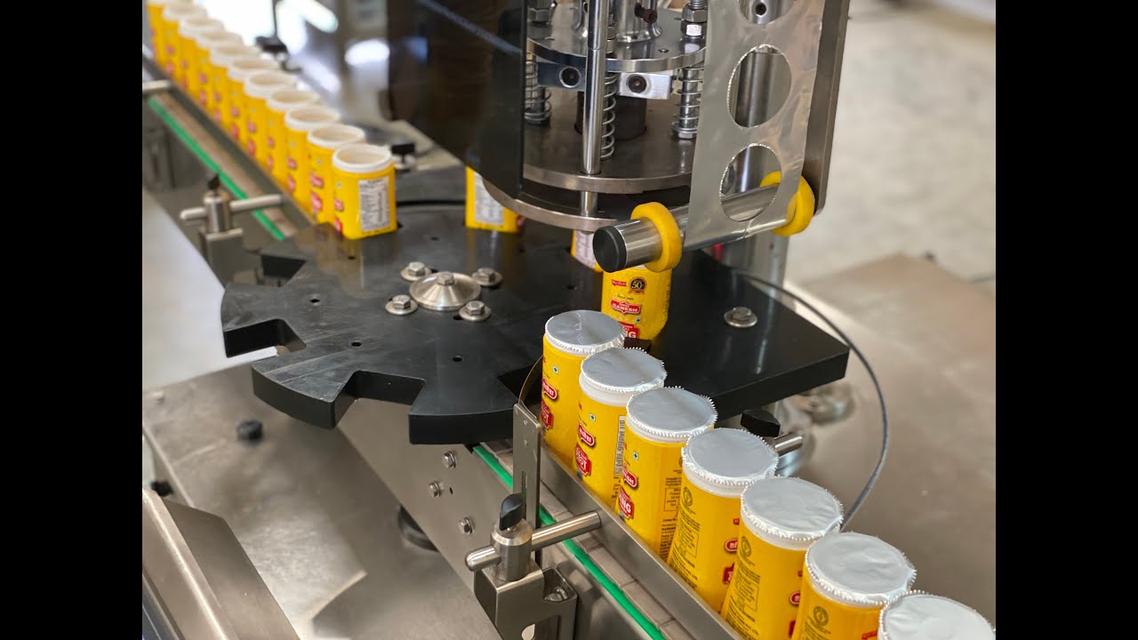 Machine that automatically seals bottle foil in under 35 words.