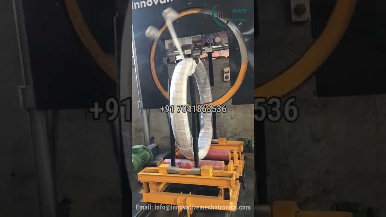 Large wire coil packaging machine for efficient stretch wrapping and steel pacing.